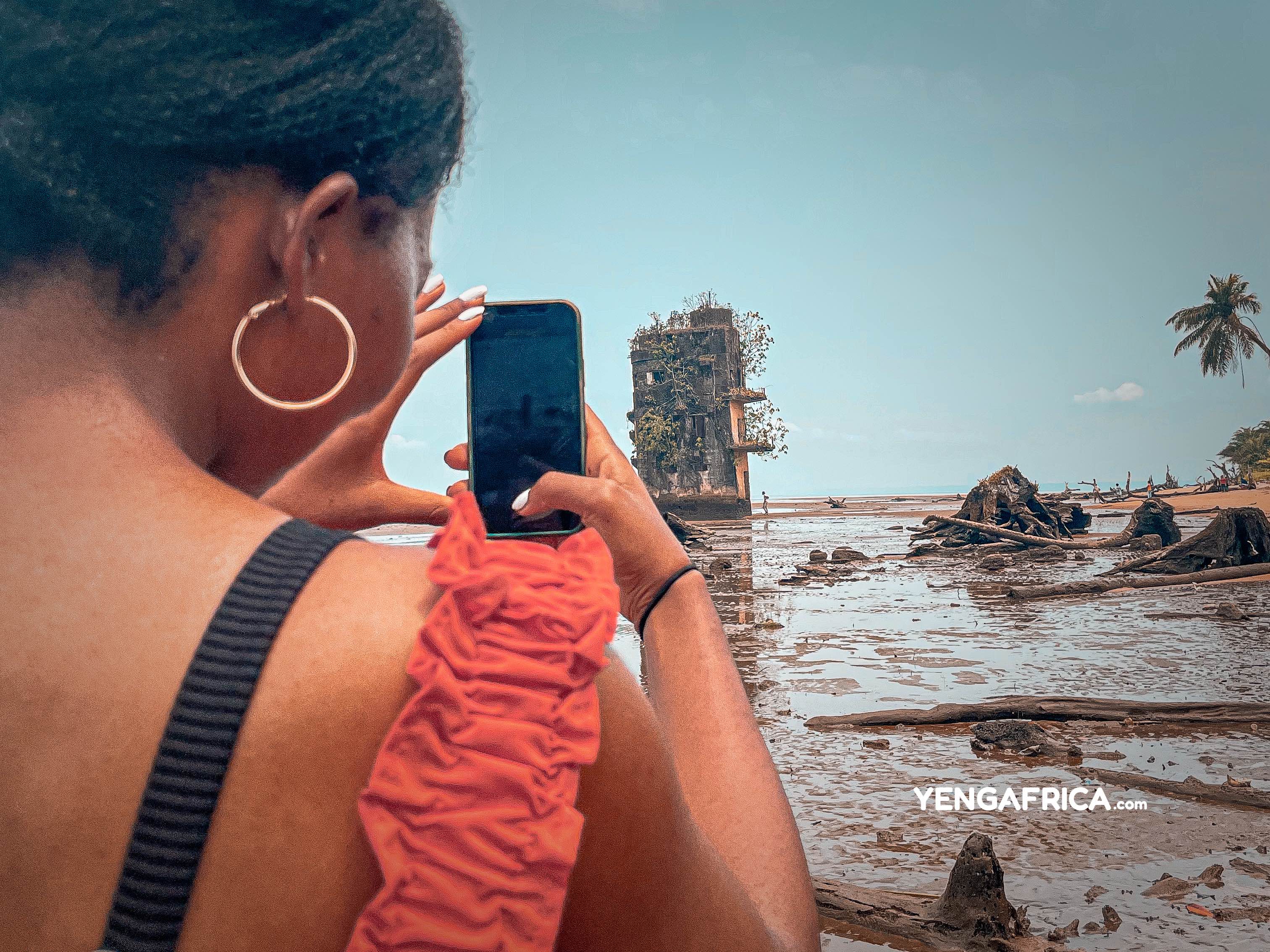 Solo female traveller capturing the manoka island prison tower - YENGAFRICA