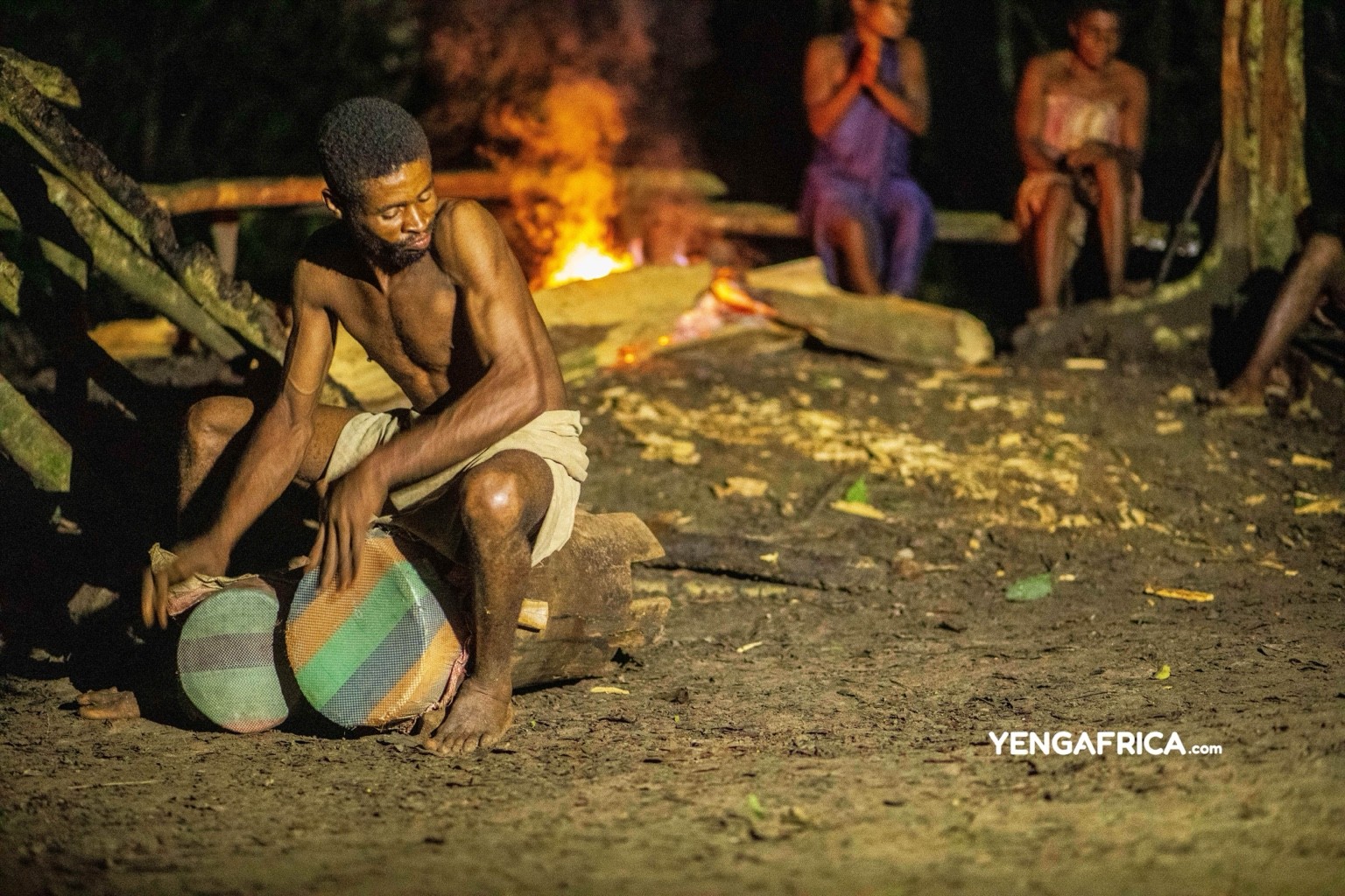 Baka community entertaining the camp at night during a guided tour.
